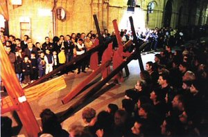 Hooded men carrying crosses through the town 